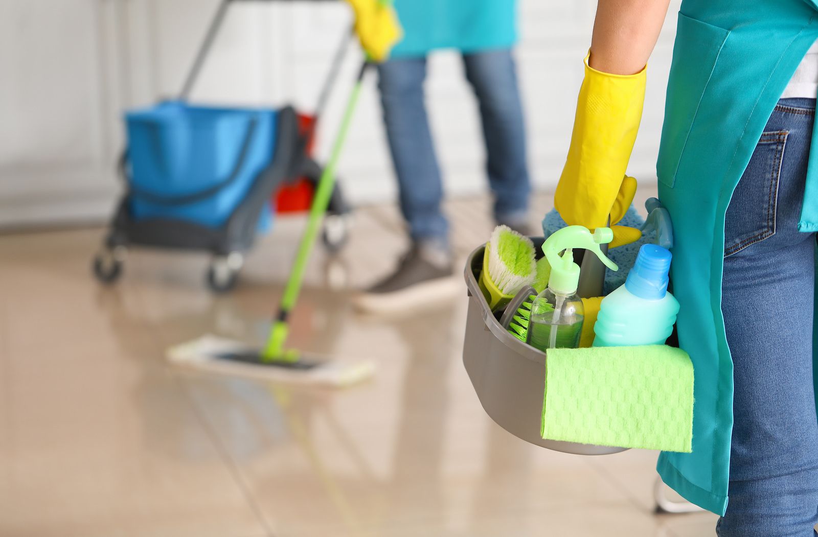Hausmeisterin mit Reinigungsmitteln in der Küche